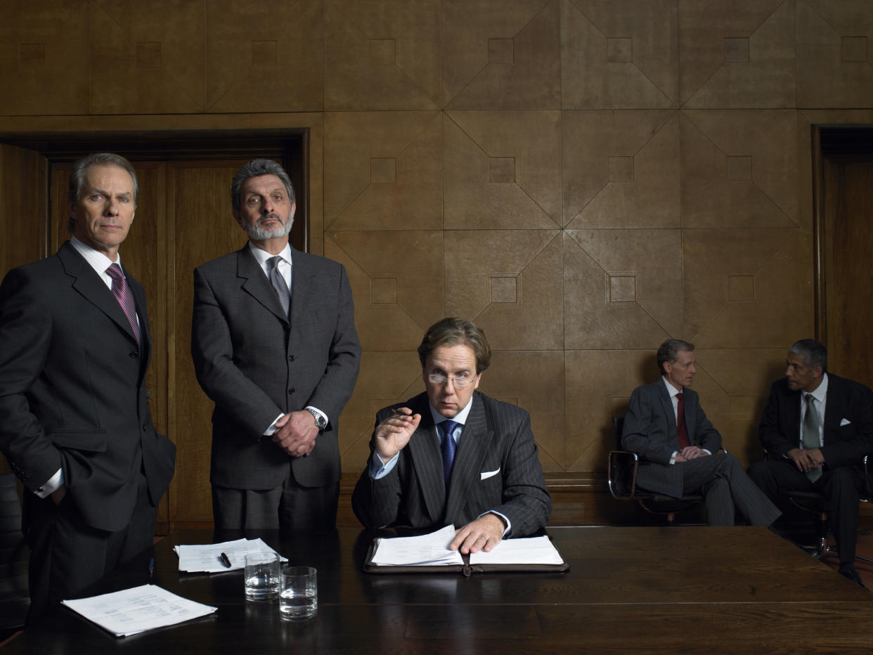 Mature men at end of table in conference room, portrait