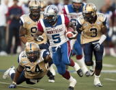 Montreal Alouettes running back Noel Devine tries to evade Winnipeg Blue Bombers Kenny Mainor(54) and Dustin Doe(3) during first quarter Canadian Football League pre-season action Thursday, June 14, 2012 in Montreal. THE CANADIAN PRESS/Ryan Remiorz