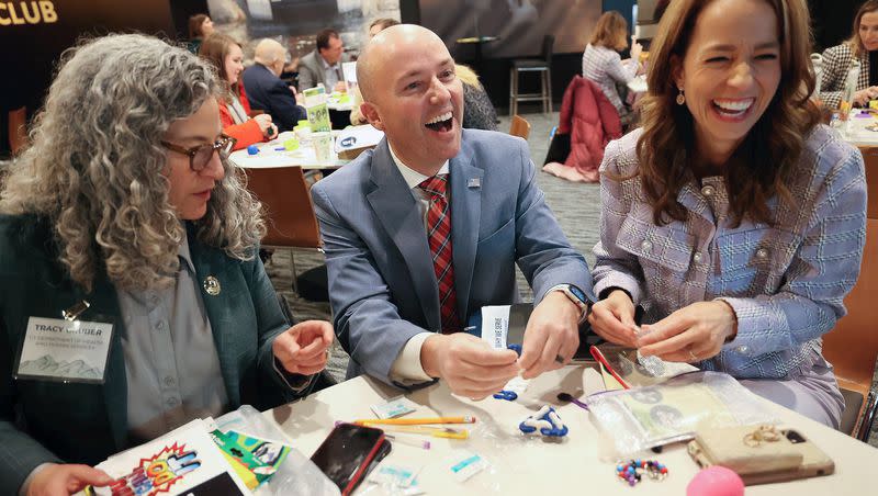 Utah Department of Health and Human Services Executive Director Tracy Gruber, Gov. Spencer Cox and first lady Abby Cox prepare Generus mental health and emotional fluency kits as part of a service project during a Why We Serve symposium at the Delta Center in Salt Lake City, on Monday, Jan. 8, 2024.