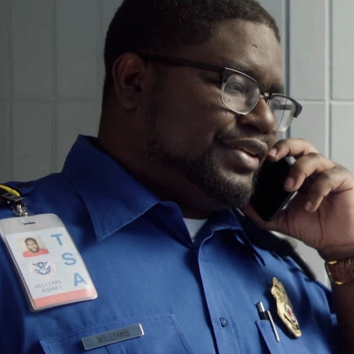 Lil Rel Howery as a TSA agent talking on the phont