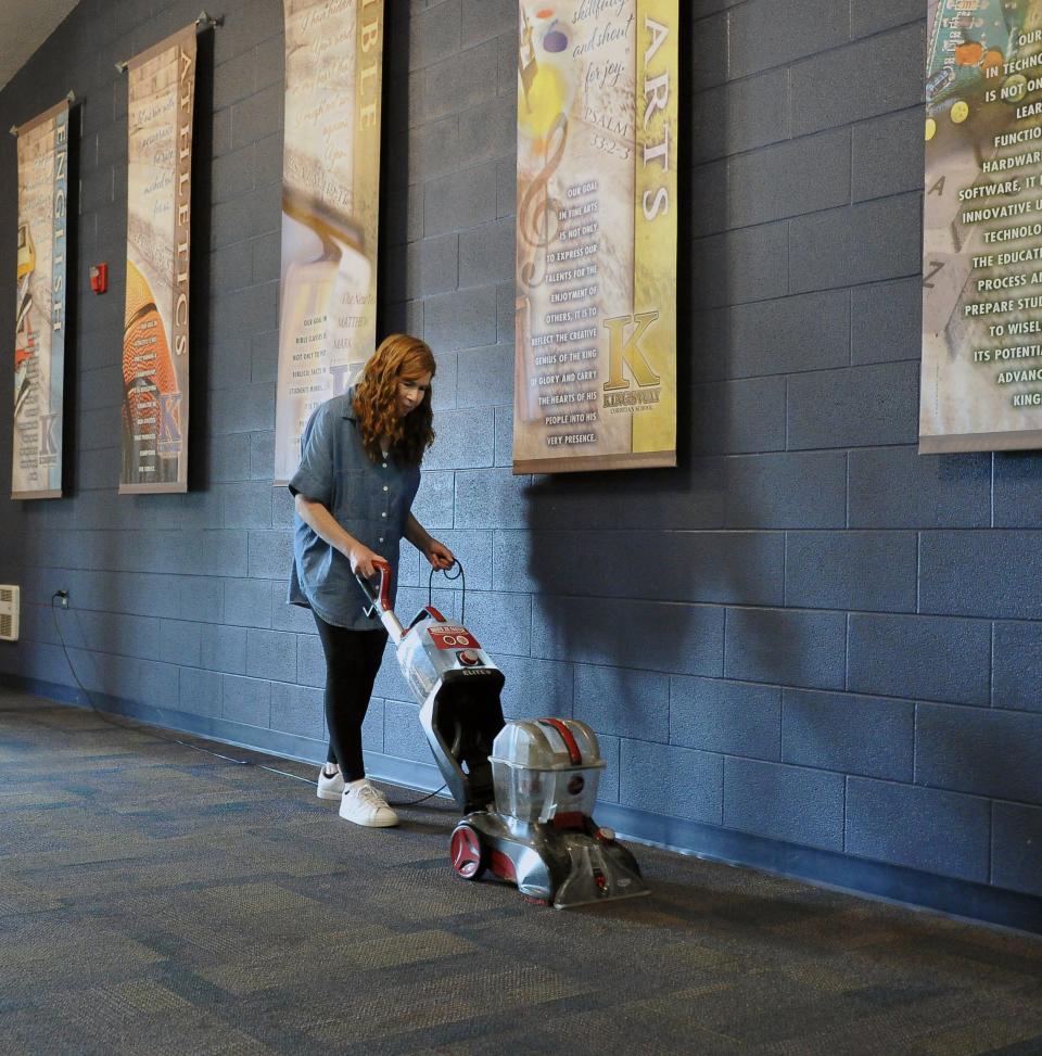 Kingsway cook/custodian Kathi Lucas is busy shampooing the carpet in the main entranceway at the high school.