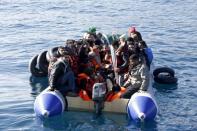 Refugees and migrants are seen on a dinghy as they approach the Ayios Efstratios Coast Guard vessel, during a rescue operation at open sea between the Turkish coast and the Greek island of Lesbos, February 8, 2016. REUTERS/Giorgos Moutafis