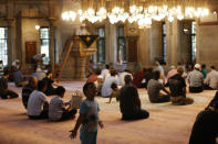 People sit in a mosque ahead of prayers in Istanbul, Wednesday, Aug. 15, 2018. The Turkish lira currency has nosedived in value in the past week over concerns about Turkey's President Recep Tayyip Erdogan's economic policies and after the United States slapped sanctions on Turkey angered by the continued detention of an American pastor. (AP Photo/Lefteris Pitarakis)