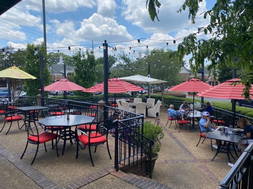 Harper’s Restaurant has a two-level patio with seating featuring bright red cushions.