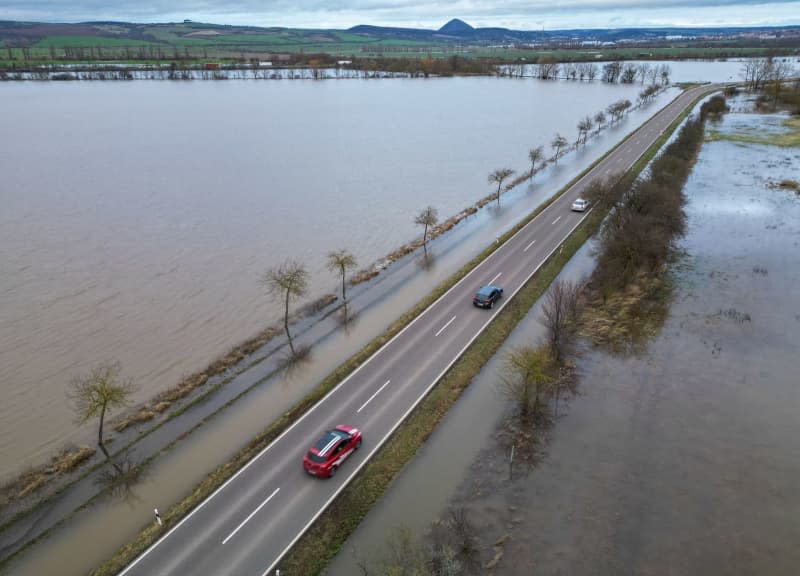 Cars drive along a road in the flooded district of Mansfeld-Suedharz. Jan Woitas/dpa