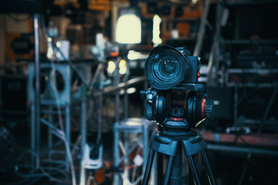 Modern camera on tripod in dark blue interior