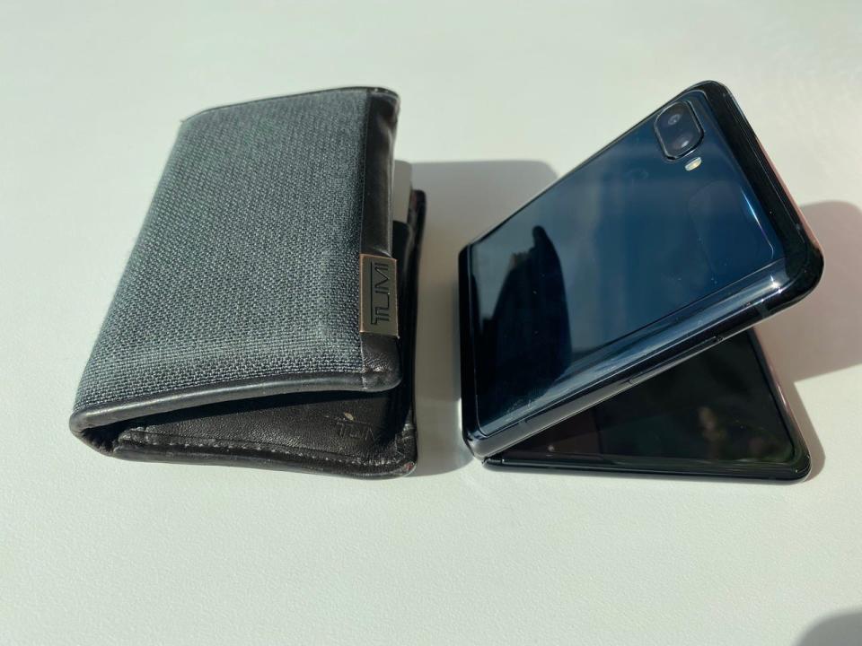 A physical Tumi wallet next to the Samsung Z Flip fold that folds like a wallet.