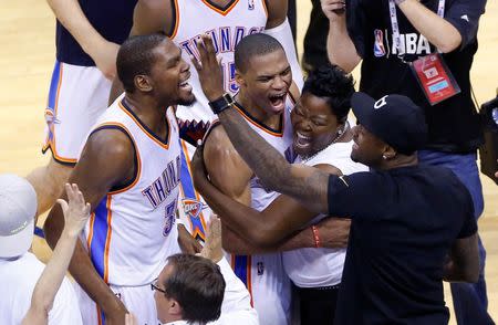 May 13, 2014; Oklahoma City, OK, USA; Oklahoma City Thunder forward Kevin Durant (left) and guard Russell Westbrook (center) celebrate their win with Kevin Durant's mother Wanda Pratt after defeating the Los Angeles Clippers in game five of the second round of the 2014 NBA Playoffs at Chesapeake Energy Arena. Oklahoma City won 105-104. Mandatory Credit: Alonzo Adams-USA TODAY Sports