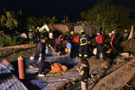 CORRECTS COUNTY - Rescue workers tend to the injured at the site of a train derailment in Yilan county, northeastern Taiwa on Sunday, Oct. 21, 2018. Passengers were killed and injured on Sunday when one of Taiwan's newer, faster trains derailed on a curve along a popular weekend route, officials said. (AP Photo)