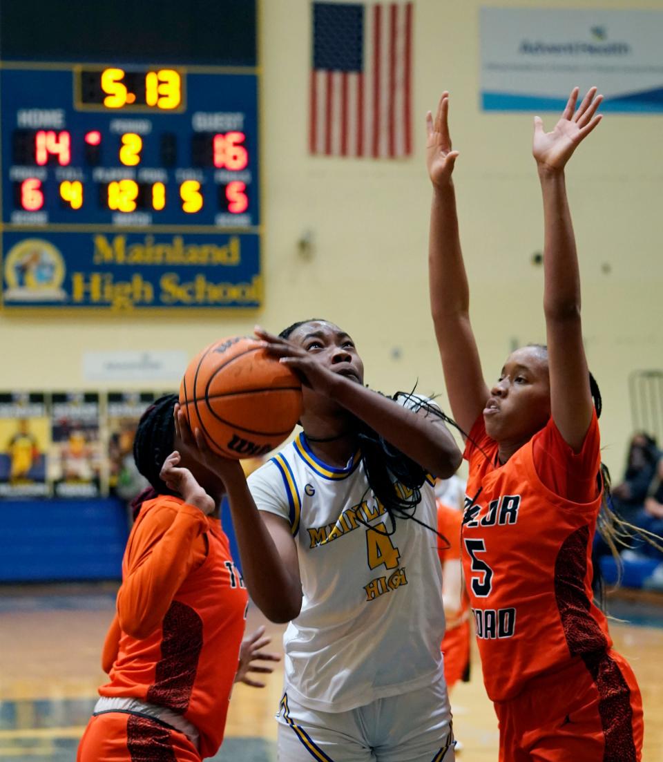 Mainland's Anovia Sheals (4) attempts to shoot around Spruce Creek's Tyja Beans at Mainland High School, Wednesday, Dec. 21, 2022.