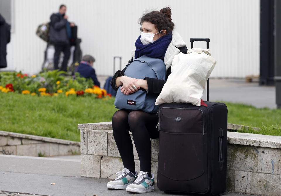 PARIS, FRANCE - MARCH 17: Passenger wearing a protective mask waits for a train at the Montparnasse station as many Parisians come to the stations of the capital to try to take a train and reach the province on March 17, 2020 in Paris, France. After the announcement of a general confinement due to an outbreak of coronavirus pandemic (COVID-19) announced by Emmanuel Macron on Monday evening, from today at noon for at least two weeks, the French will have to stay at home, under penalty of sanctions, unless travel is absolutely necessary, announced the head of state. President launched the war against the coronavirus and placed France in containment without ever saying the word. The Coronavirus epidemic has exceeded 7,500 dead for more than 189,000 infections across the world. (Photo by Chesnot/Getty Images)