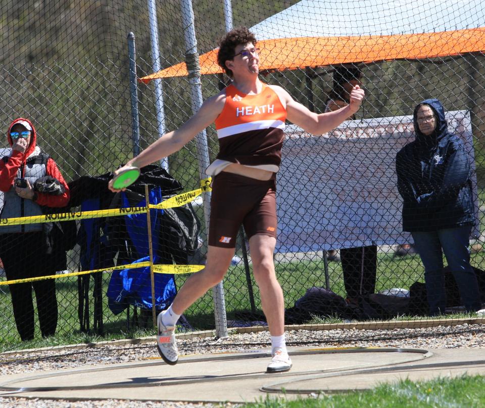 Heath's Carter Higgins throws the discus during the Bulldogs' Hank Smith Invitational on Saturday.
