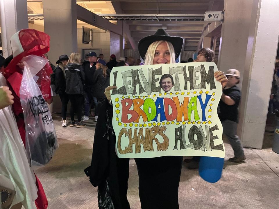 fan smiling and holding sign at morgan wallens concert