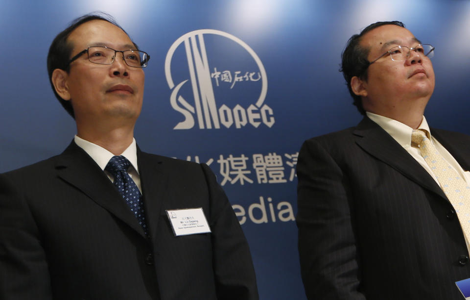 Sinopec representatives, News Spokesperson Lu Dapeng, and Vice President of Sinopec Chemical Commercial Holdings Company Ltd. Zhang Guoming attend a press conference in Hong Kong Thursday Aug. 9, 2012. Chinese oil company Sinopec, Thursday, is promising to clean up millions of its tiny plastic pellets that washed up on beaches across Hong Kong after they fell off a ship during a strong typhoon. (AP Photo/Kin Cheung)