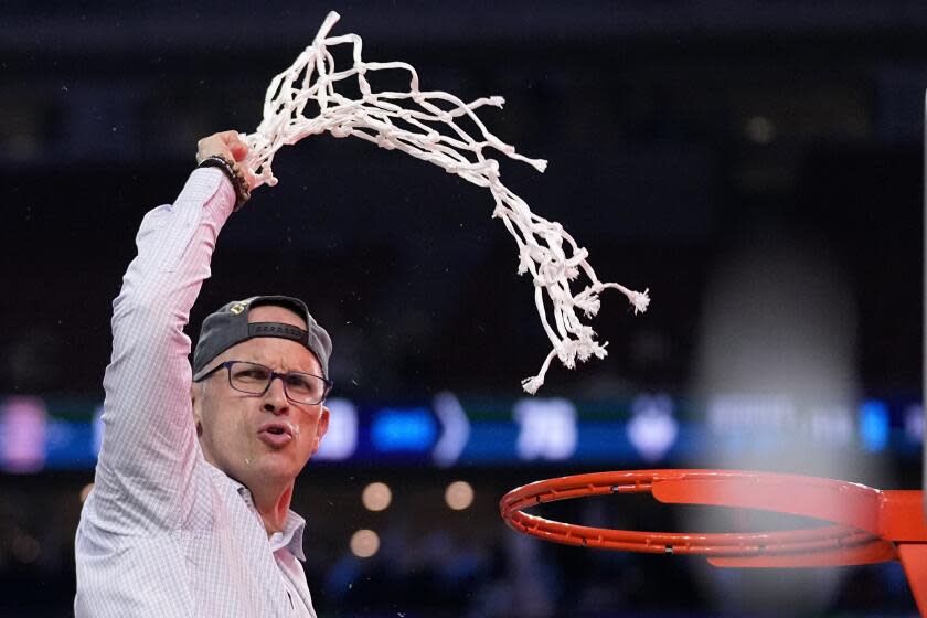 UConn coach Dan Hurley waves the net to celebrate winning the national championship