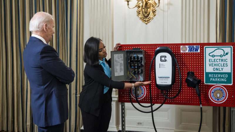President Joe Biden watches an electric vehicle charger demonstration at the White House.