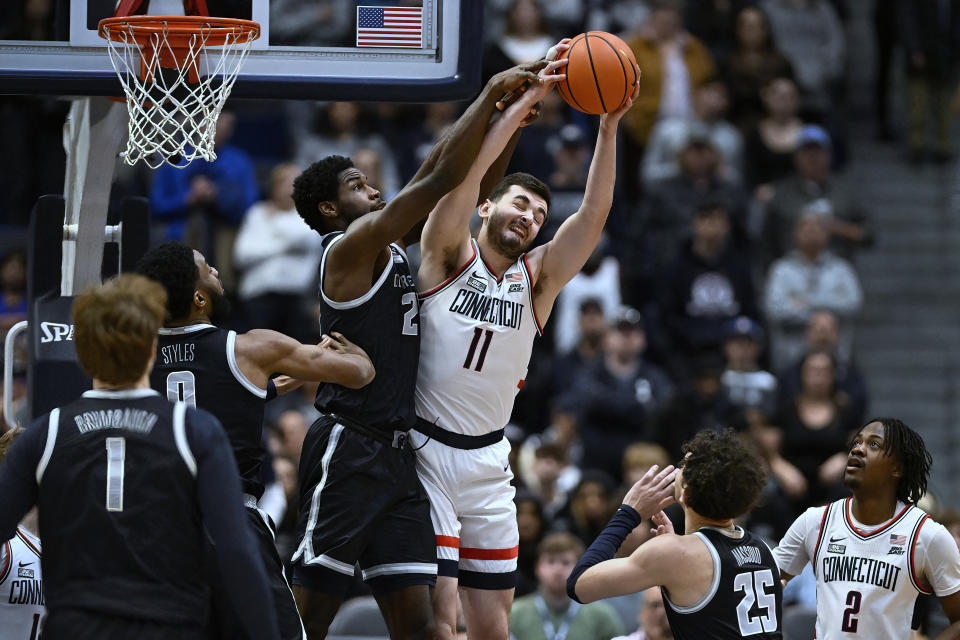 UConn forward Alex Karaban (11) pulls down a rebound against Georgetown forward Supreme Cook in the first half of an NCAA college basketball game, Sunday, Jan. 14, 2024, in Hartford, Conn. (AP Photo/Jessica Hill)