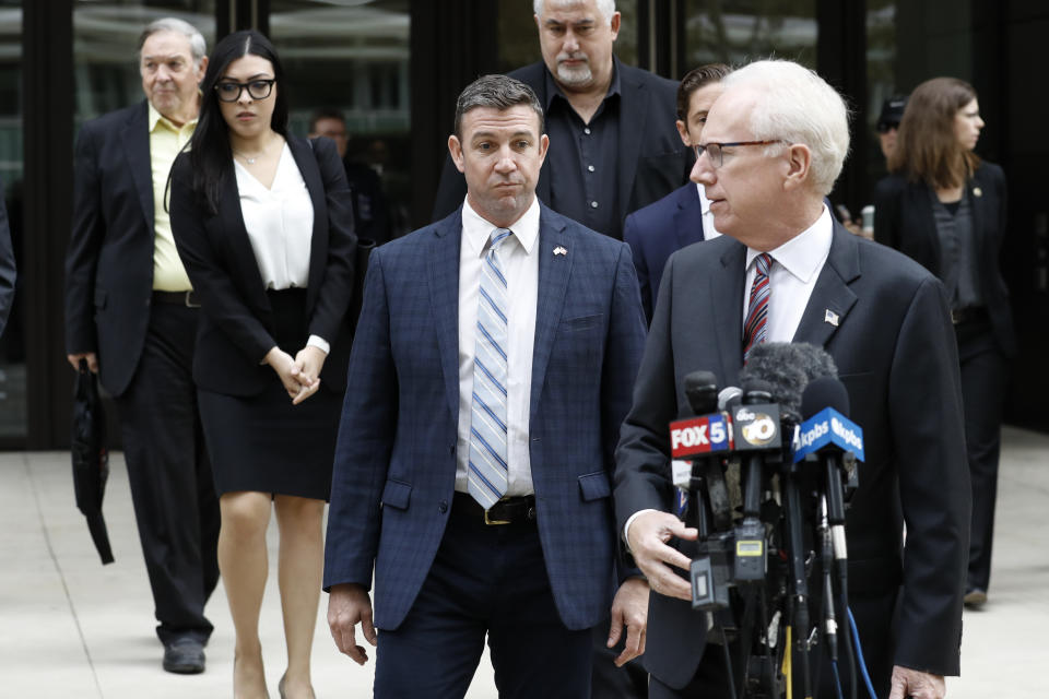 California Republican Rep. Duncan Hunter, center, walks out of federal court Tuesday, Dec. 3, 2019, in San Diego. Hunter gave up his year-long fight against federal corruption charges and pleaded guilty Tuesday to misusing his campaign funds, paving the way for the six-term Republican to step down. (AP Photo/Gregory Bull)