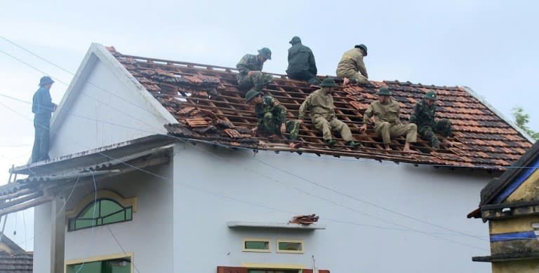 Soldiers fix the damaged roof of a local home in the central province of Quang Ngai after Typhoon Damrey hit central Vietnam