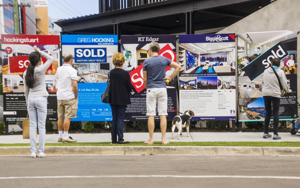 Visitors reading a row of estate agent signs outside a newly-renovated apartment building. Source: Getty Images