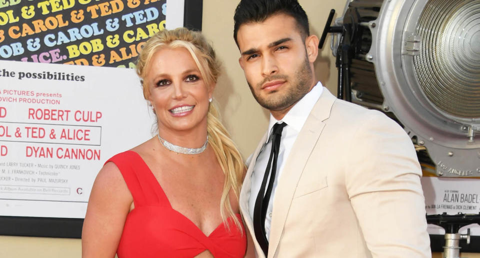 Britney Spears and Sam Asghari posing together on the red carpet