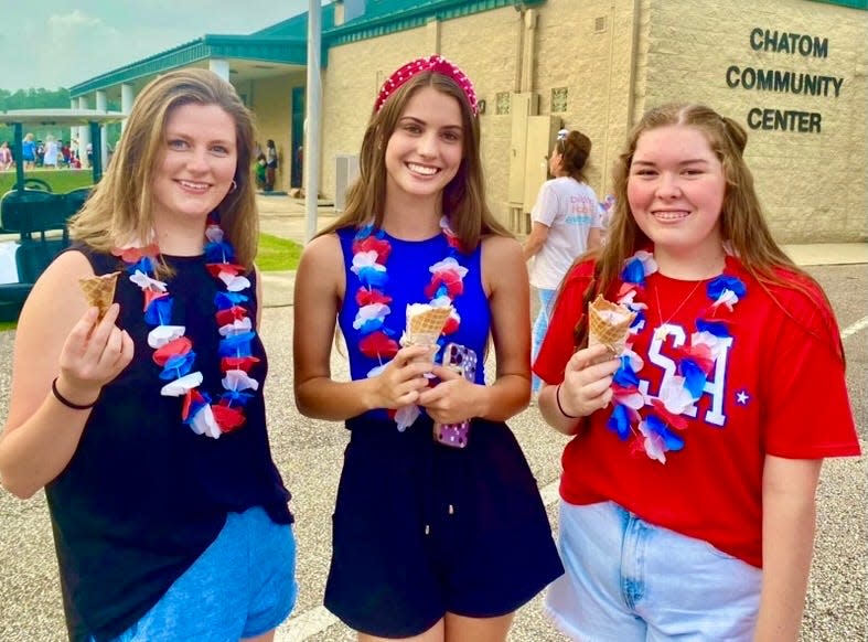 From left, Hayley Platt, Katelyn Beech and Katelyn Singleton enjoy ice cream from Havens Down Home Creamery of Lucedale, Mississippi, during the annual Independence Day celebration in Chatom, Alabama, on July 3, 2023.