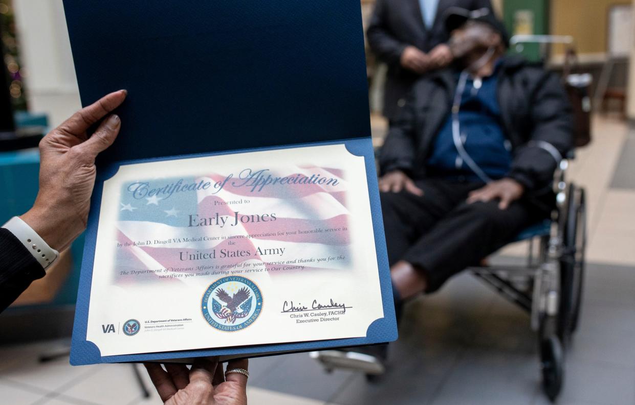 One of World War II veteran Early Jones' daughters holds her father's certificate inside John D. Dingell VA Medical Center in Detroit on Thursday, Dec. 7, 2023.