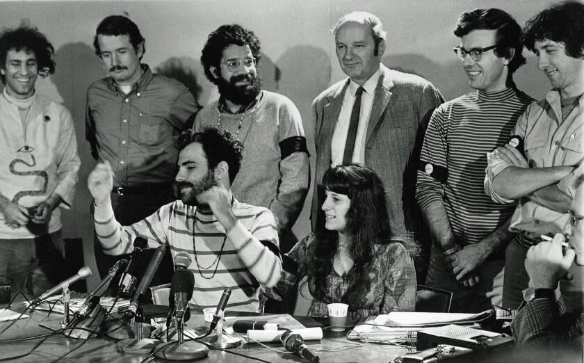 The Chicago Seven defendants hold a news conference in Chicago, Ill., during their 1969 trial on charges of conspiracy to riot at the 1968 Democratic National Convention. From left, standing, are: Abbie Hoffman, John Froines, Lee Weiner, Dave Dellinger, Rennie Davis and Tom Hayden. Seated is defendant Jerry Rubin, with his girlfriend, Nancy Kurshan, who was not part of the trial. (AP Photo)