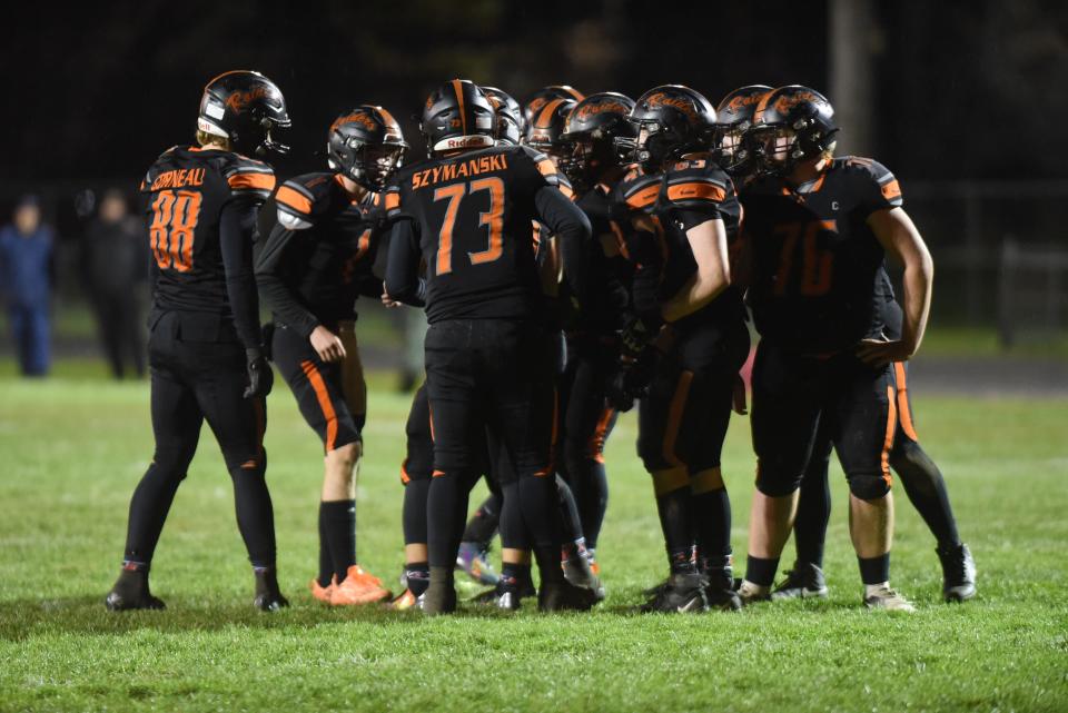 The Almont football team huddles up during a Division 6 district final against Warren Michigan Collegiate at Almont High School on Nov. 3.