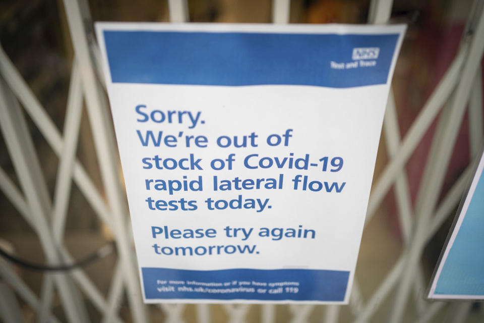 A sign saying lateral flow coronavirus tests are out of stock is displayed in a pharmacy window in London, Thursday Dec. 30, 2021. The U.K. reported a record 183,037 confirmed new coronavirus infections on Wednesday, 32% more than the previous day. While early data suggests omicron is less likely to cause serious illness than earlier variants, public health officials think the sheer number of infections could lead to a jump in hospitalizations and deaths.(Dominic Lipinski/PA via AP)