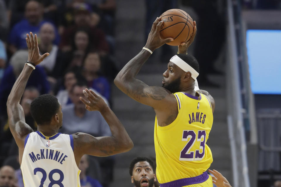 Los Angeles Lakers forward LeBron James (23) passes the ball against Golden State Warriors forward Alfonzo McKinnie (28) during the first half of a preseason NBA basketball game in San Francisco, Saturday, Oct. 5, 2019. (AP Photo/Jeff Chiu)