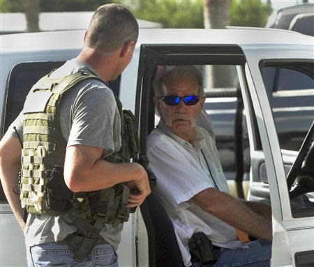Pastor Terry Jones, (R), talks to a member of the Polk County Sheriff's Department as he sits in his vehicle prior to his arrest after being pulled over while travelling on State Road 37 in Mulberry, Florida September 11, 2013. REUTERS/Michael Wilson/The Lakeland Ledger