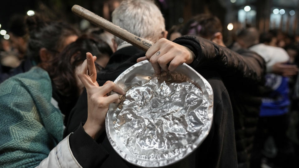 An anti-government protester crosses her fingers during a pot-banging rally outside Congress, where lawmakers debate a reform bill presented by President Javier Milei in Buenos Aires, Argentina, Wednesday, June 12, 2024. The bill was approved in general and must now be debated article-by-article before being sent to the Lower House. (AP Photo/Rodrigo Abd)