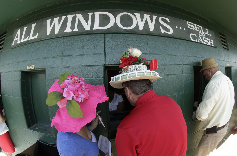 Fans make wagers before the 140th running of the Kentucky Derby horse race at Churchill Downs Saturday, May 3, 2014, in Louisville, Ky. (AP Photo/Charlie Riedel)