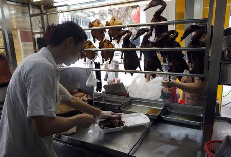 An employee chops up roast duck at Hong Kong Jin Tian Eating House in Singapore April 17, 2014. REUTERS/Edgar Su