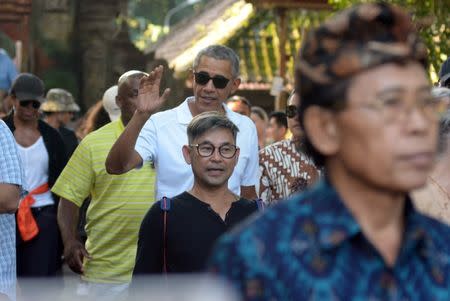 Former United States President Barack Obama waves during a visit to Tirta Empul Temple while on holiday with his family in Gianyar, Bali, Indonesia June 27, 2017 in this photo taken by Antara Foto. Antara Foto/Wira Suryantala/ via REUTERS