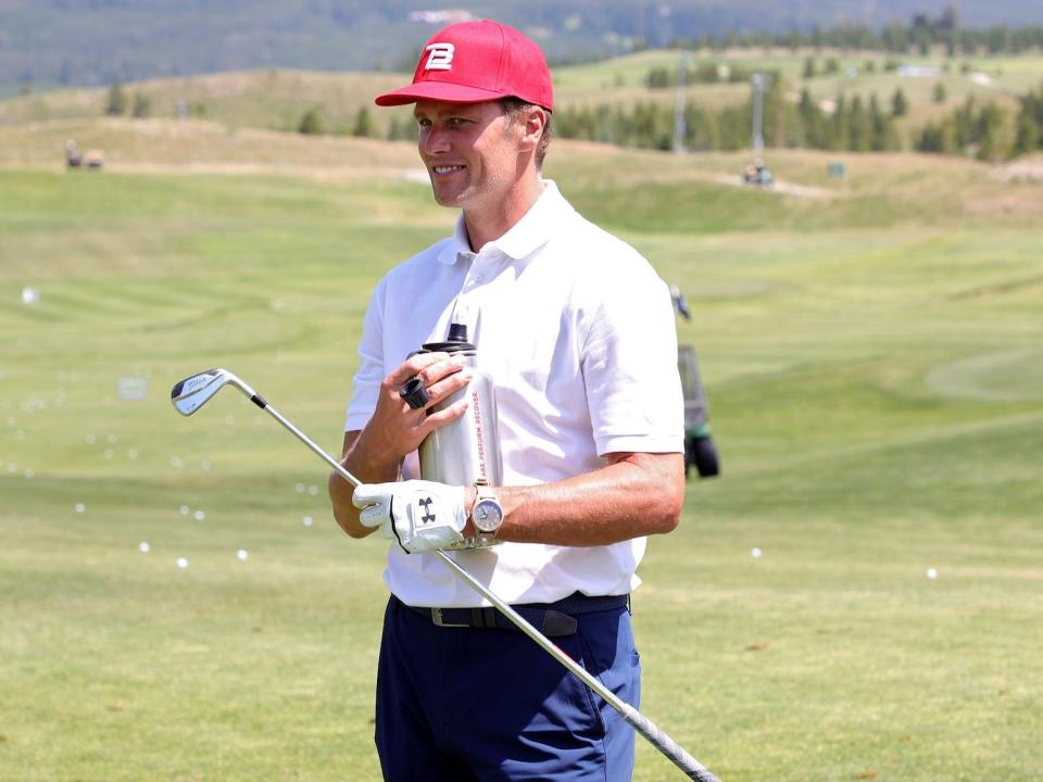 Tom Brady holds a golf club during "The Match" in 2021.