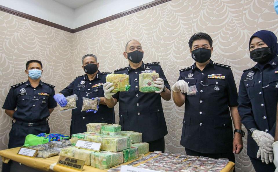 Perak police chief commissioner Datuk Mior Faridalathrash Wahid (centr) holds up drugs seized at the state police headquarters in Ipoh February 26, 2021. — Picture by Farhan Najib