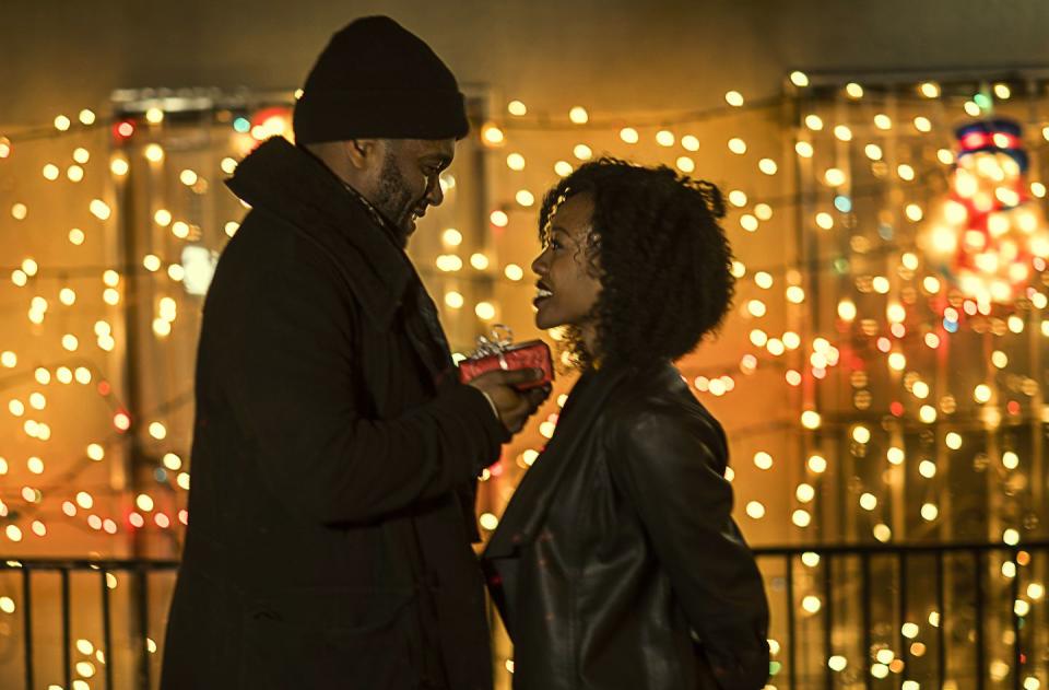 romantic happy couple enjoying city during winter holidays giving gifts in front of holiday lights