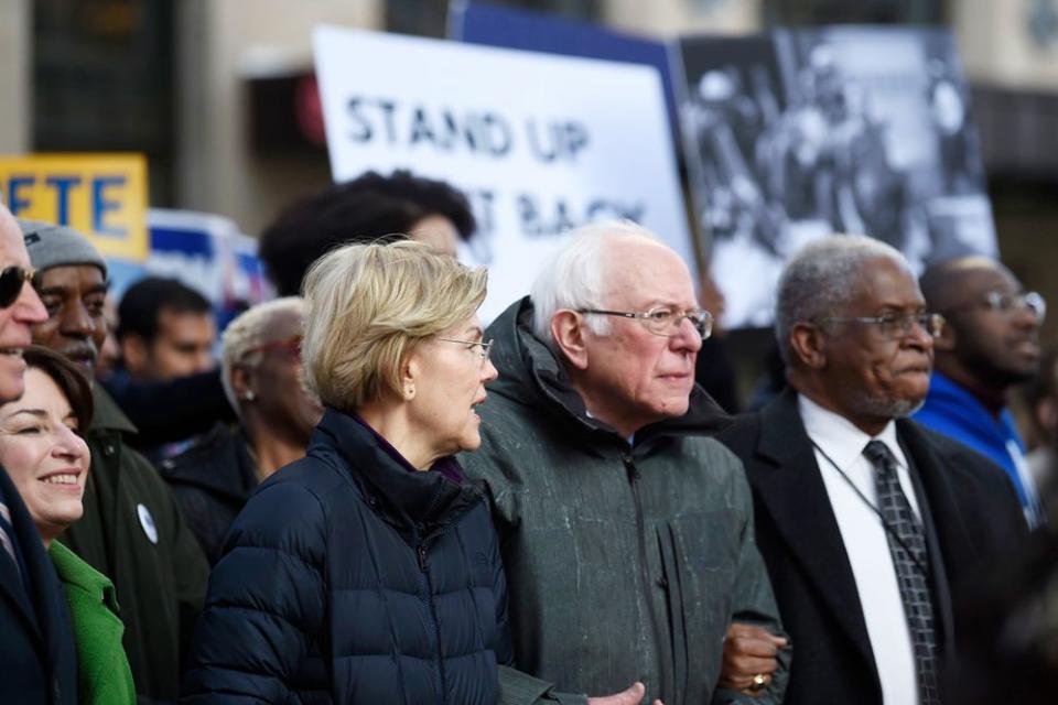 Sens. Bernie Sanders and Elizabeth Warren link arms and talk during a Martin Luther King Jr. Day march in Columbia, South Carolina on Monday | Meg Kinnard/AP/Shutterstock