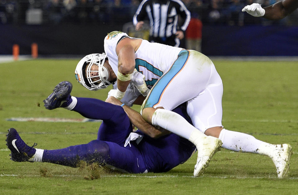 Miami Dolphins middle linebacker Kiko Alonso, top, collides with Baltimore Ravens quarterback Joe Flacco as Flacco slides on the field after rushing the ball in the first half. (AP)