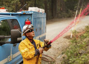 Pacific Gas & Electric firefighter Dave Ronco sprays retardant on a utility pole to protect infrastructure as the Mosquito Fire burns near Volcanoville in El Dorado County, Calif., on Friday, Sept. 9, 2022. (AP Photo/Noah Berger)