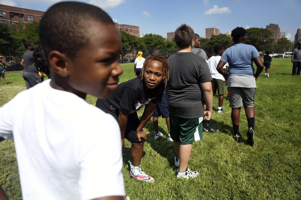 Mason Washington, 11, center, warms up with teammates at the first football practice of the season on Sunday, Aug. 9, 2020, in Brooklyn borough of New York. (AP Photo/Jessie Wardarski)