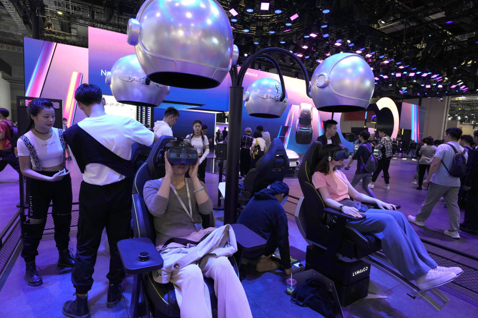 Attendees take part in virtual reality experiences at the Auto Shanghai 2023 show in Shanghai, Tuesday, April 18, 2023. Global and Chinese automakers plan to unveil more than a dozen new electric SUVs, sedans and muscle cars this week at the Shanghai auto show, their first full-scale sales event in four years in a market that has become a workshop for developing electrics, self-driving cars and other technology. (AP Photo/Ng Han Guan)