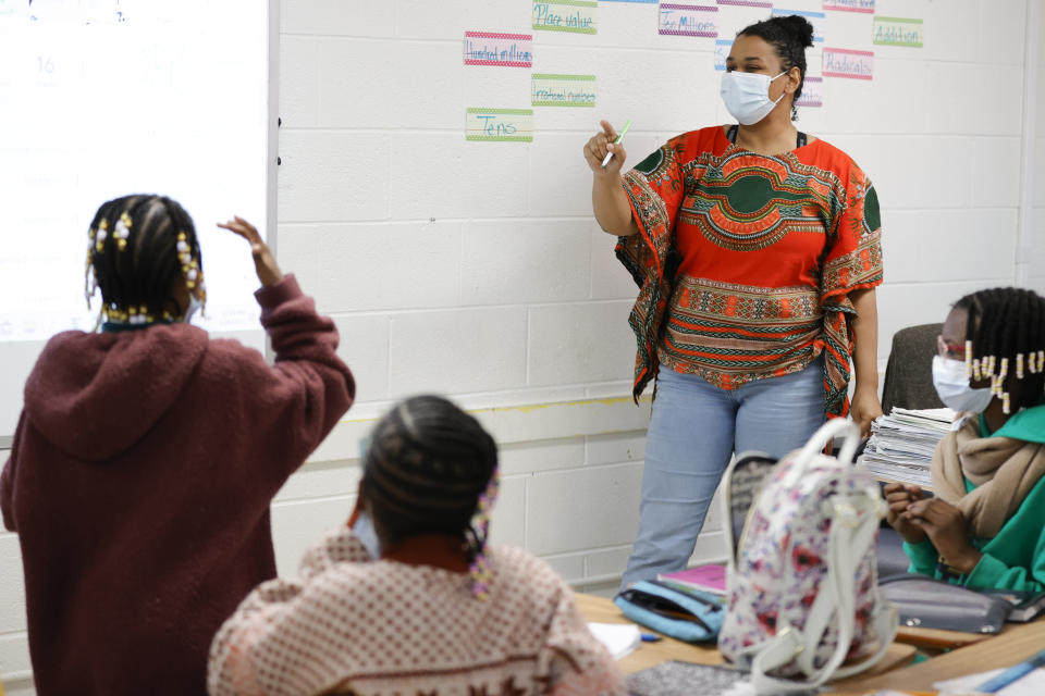 Tashiya Umoja M'kanga, of Atlanta, right, instructs students during a math lesson at the Kilombo Academic and Cultural Institute, Tuesday, March 28, 2023, in Decatur, Ga. (AP Photo/Alex Slitz)