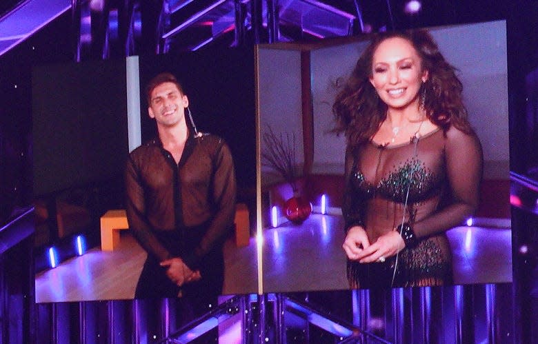 Cody Rigsby and Cheryl Burke on the "DWTS" screen. Due to positive COVID-19 tests, the dancers danced along at home, and were brought together by split-screen technology.