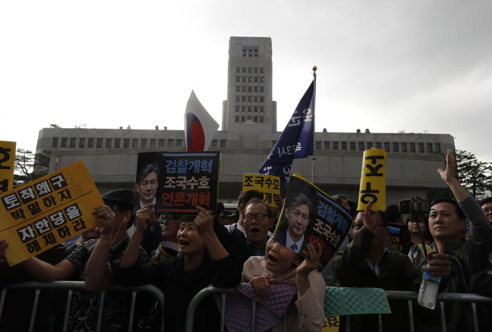 Supporters of South Korea's Justice Minister Cho Kuk hold banners with photos of Cho during a rally in Seoul, South Korea, Saturday, Oct. 5, 2019. The letters read "Protect Cho Kuk" and "Reform the Prosecution." (AP Photo/Lee Jin-man)