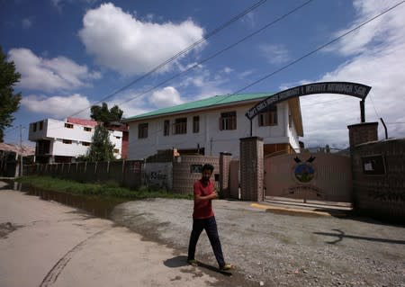 A Kashmiri man walks past a school, during restrictions after the scrapping of the special constitutional status for Kashmir by the government, in Srinagar