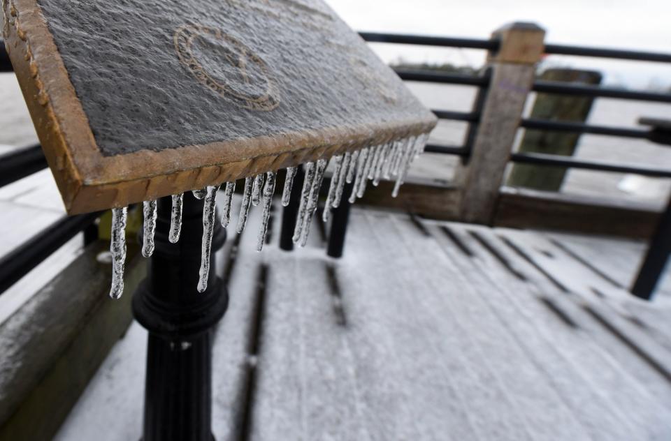 Ice hangs from a sign along the Riverwalk in Wilmington, N.C., Saturday Jan. 22, 2022. A wintry mix fell throughout the night over the Wilmington area and created dangerous conditions.   [MATT BORN/STARNEWS]