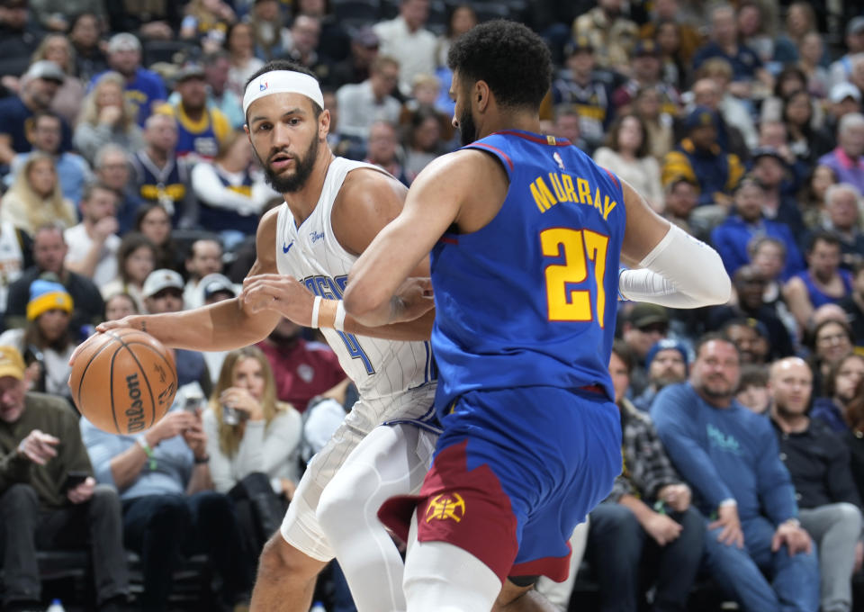 Orlando Magic guard Jalen Suggs, left, drives to the basket as Denver Nuggets guard Jamal Murray, right, defends in the first half of an NBA basketball game Friday, Jan. 5, 2024, in Denver. (AP Photo/David Zalubowski)